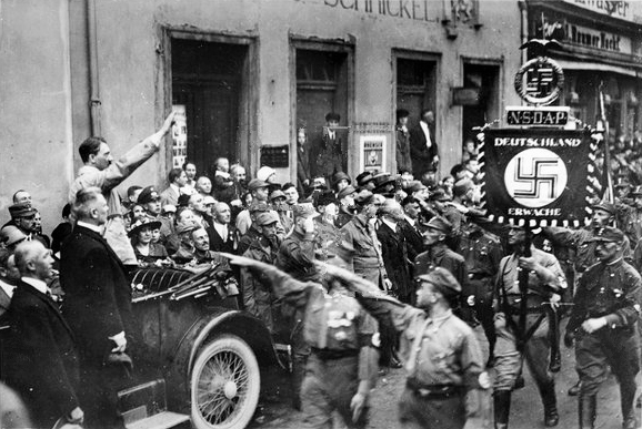 Adolf Hitler in his car in front of the parade of the SA during the second party rally in Weimar